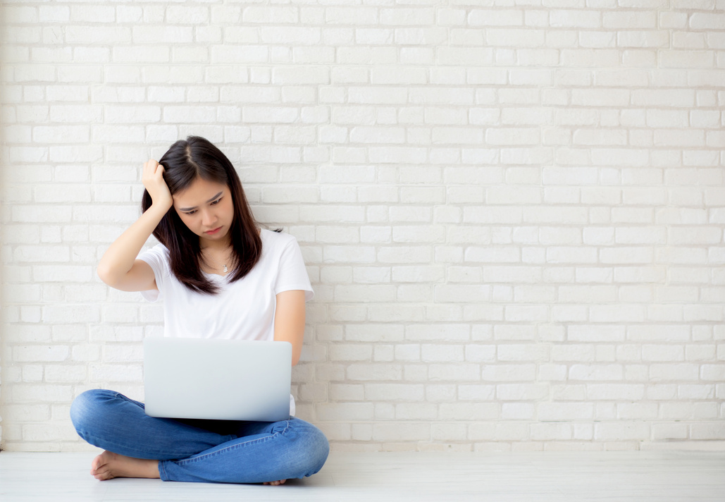 Frustrated Woman Sitting on the Floor Working on Laptop 
