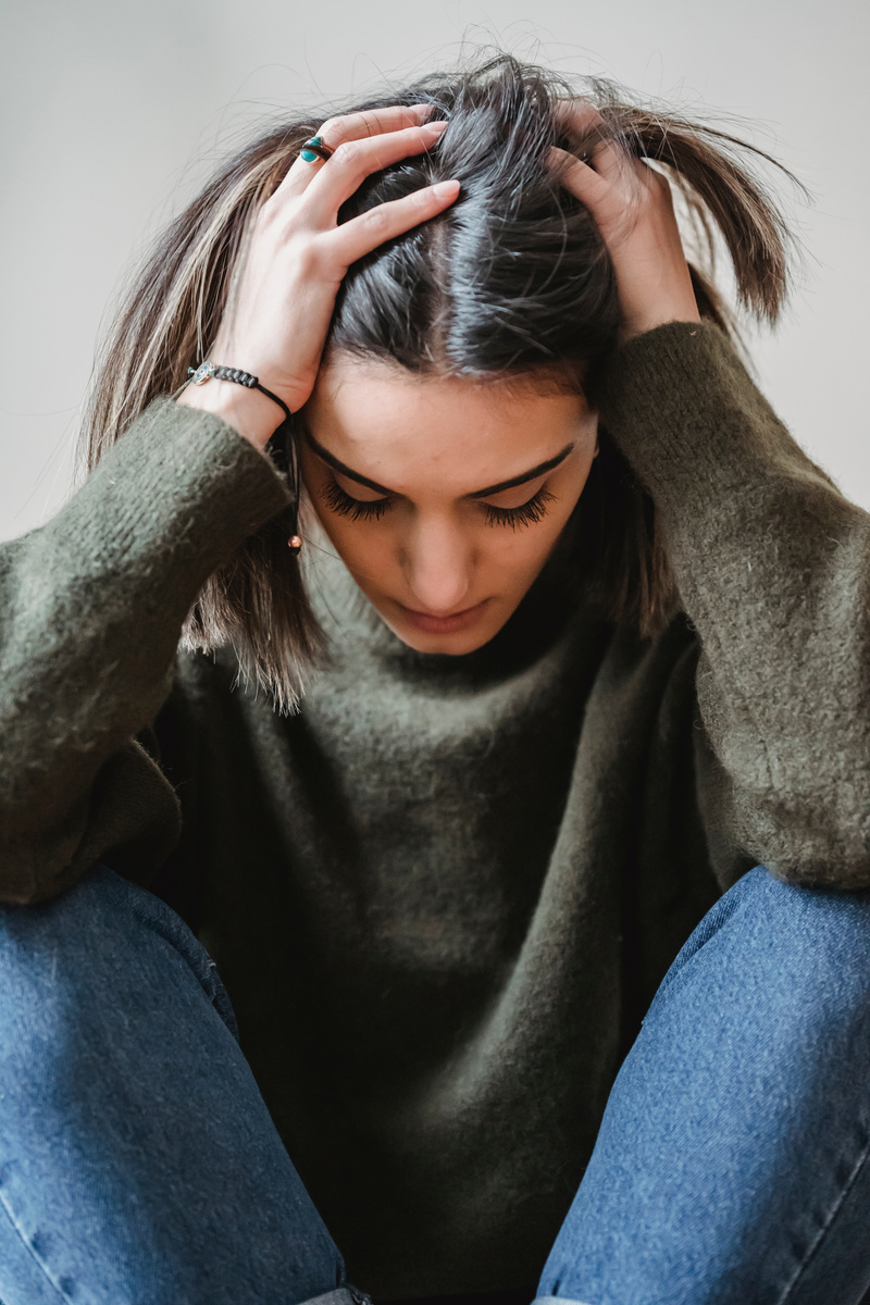 Despaired woman touching head in room